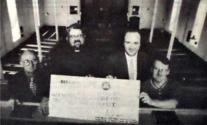 church elder Alex Davidson and Rev Donald Loosemore gratefully accepting the cheque